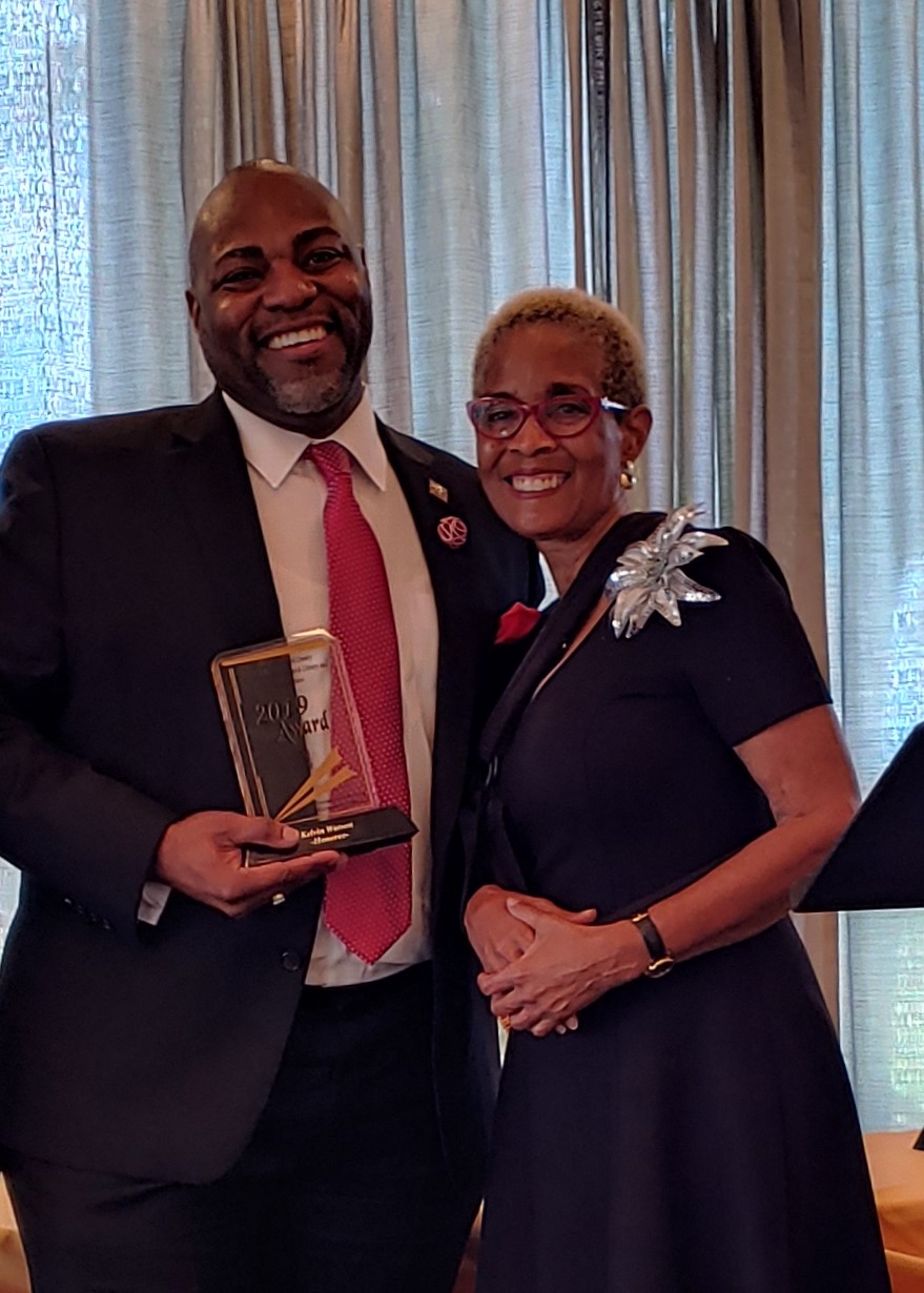 Library Director Kelvin Watson receives the Friends of AARLCC Community Service Award from AARLCC Friends President Pamela Adams