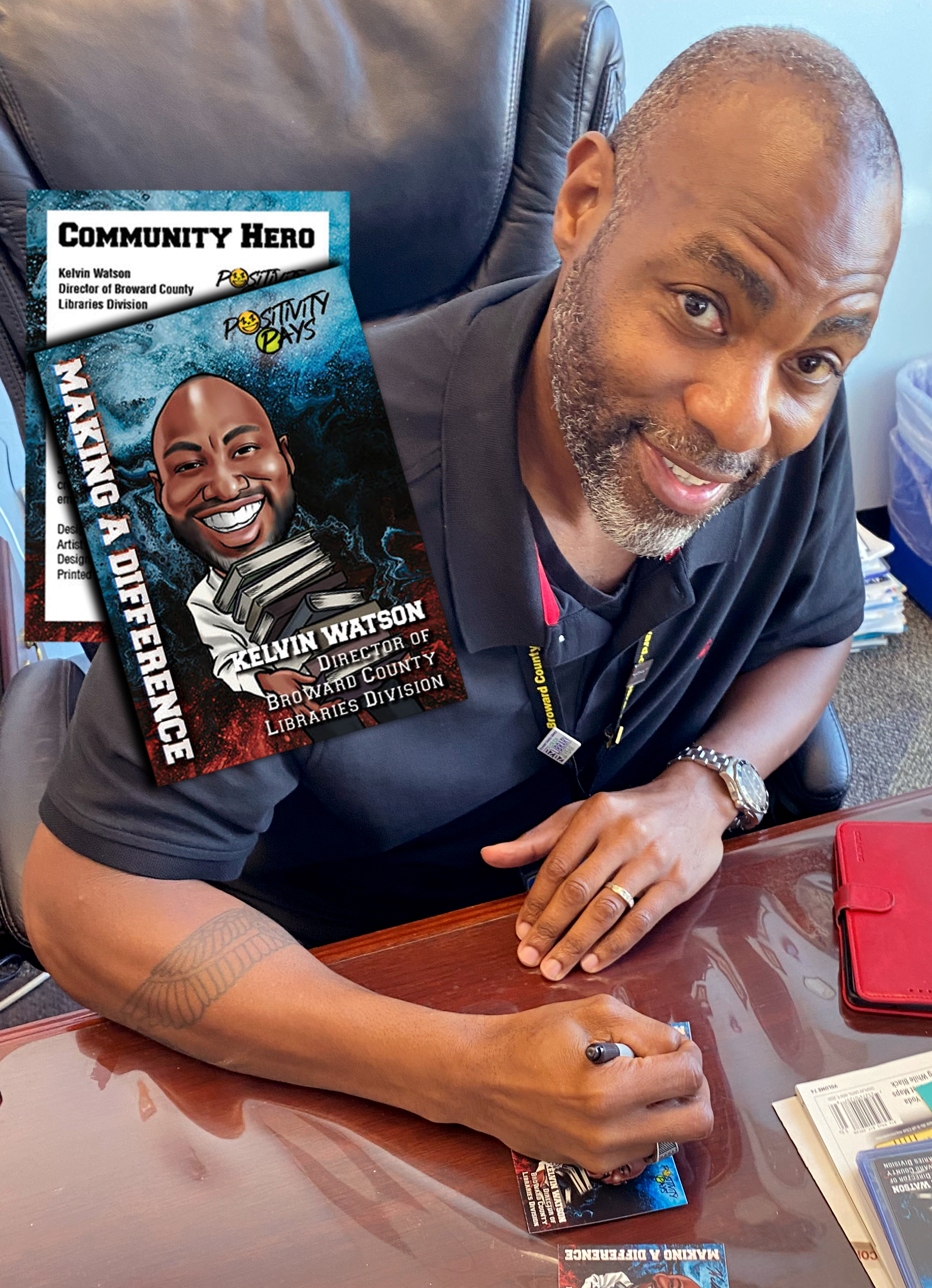 Broward County Library Director Kelvin Watson signs his Community Hero Trading Card.