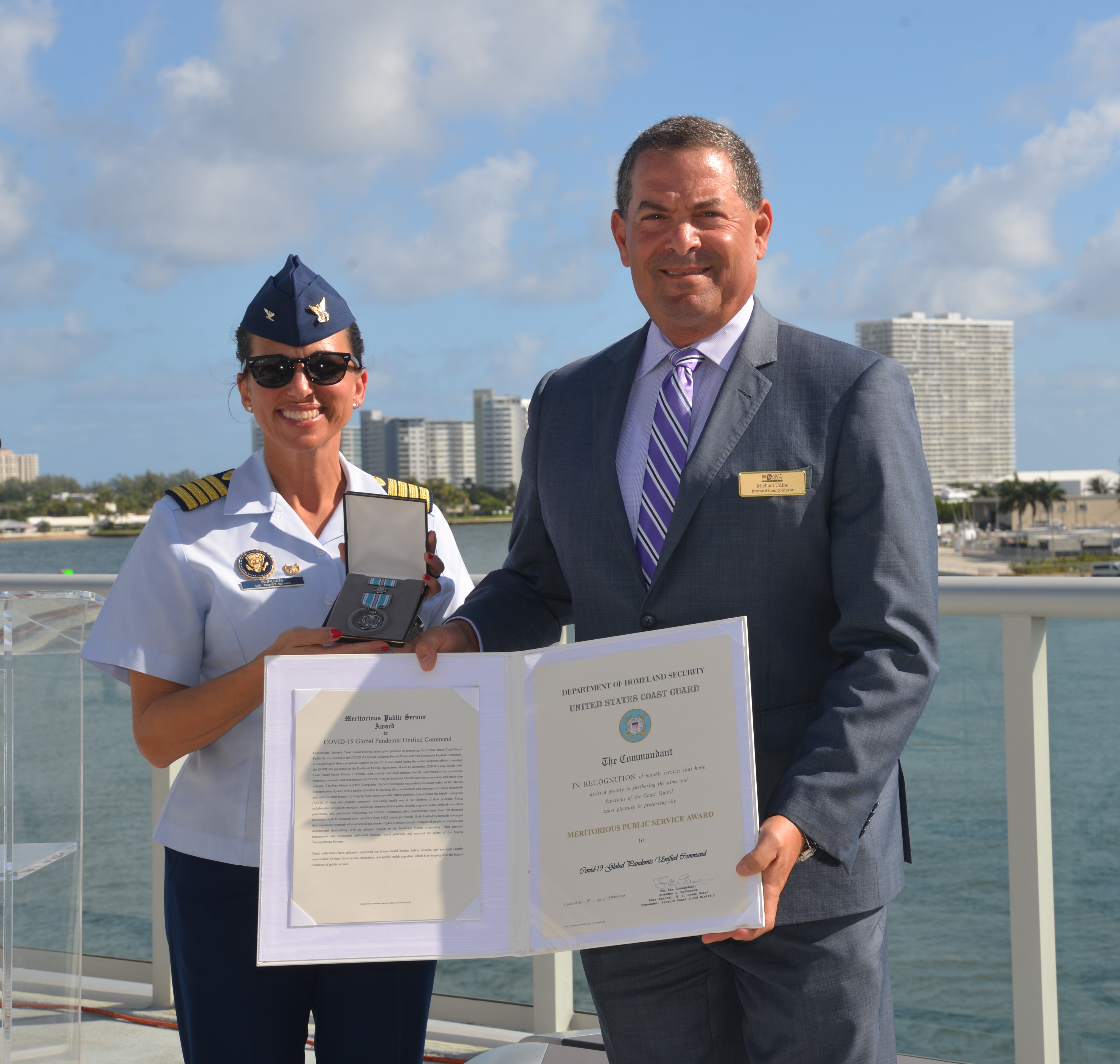 U.S. Coast Guard Captain JoAnn Burdian presents Broward County Mayor Michael Udine with the Meritorious Public Service Award for the Port Everglades Unified Command.