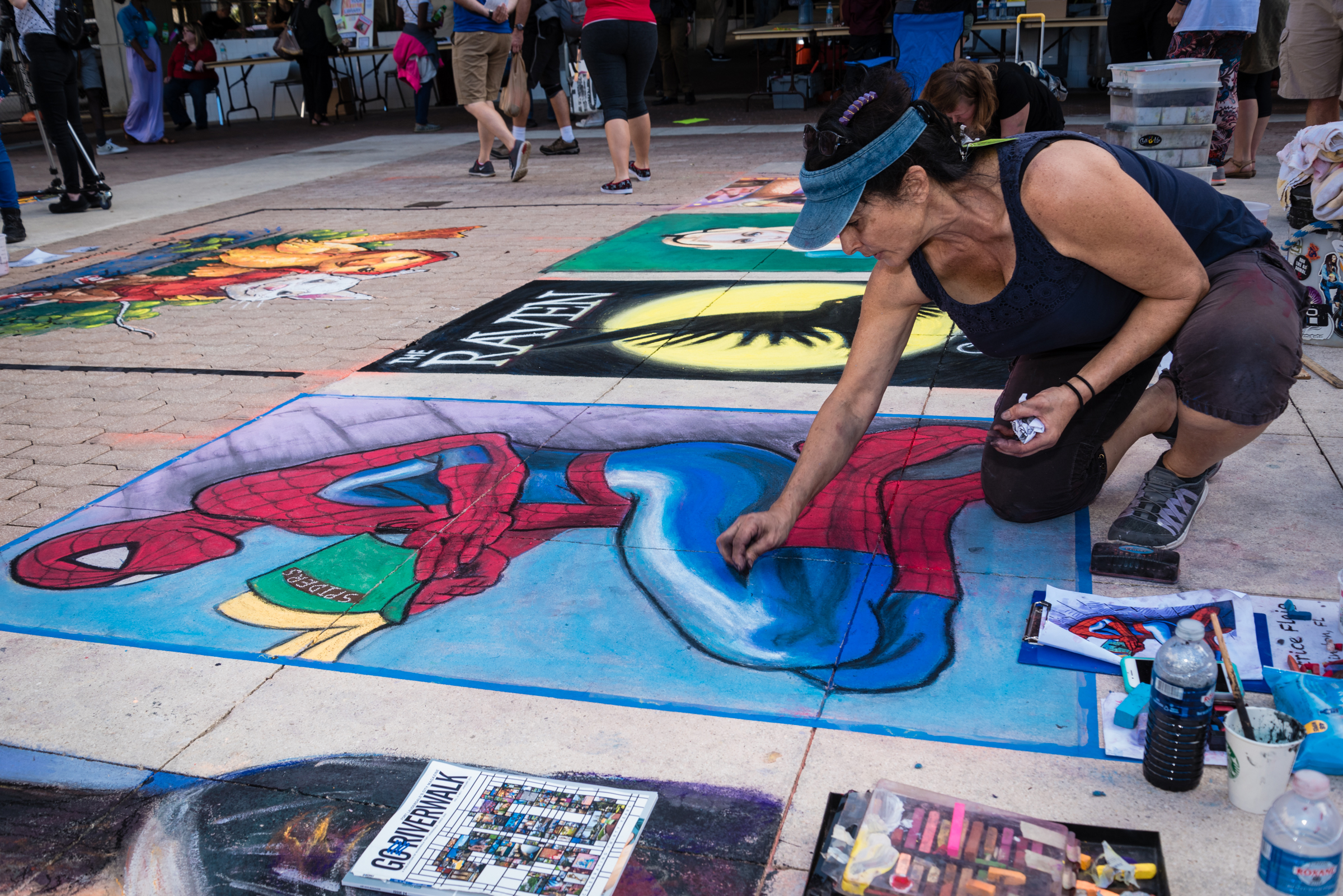 Chalk artists creating a mural at ArtLit 2018.
