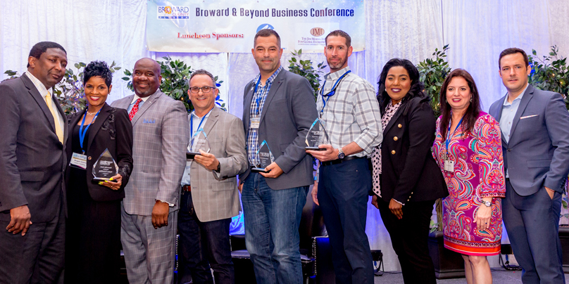 Honoring TEAM UP Broward Mentors (Left to Right): Vice Mayor Dale V.C. Holness; Dr. Reggie Lewis, Fusion Consulting; OESBD Director Sandy-Michael McDonald; Justen Shiff, Shiff Construction & Development, Inc.; Paul Weinberg, KEITH; Derek Bixby, The Weitz Company; Commissioner Barbara Sharief; Deputy County Administrator Monica Cepero; and luncheon MC Jeff Lennox, WSVN 7
