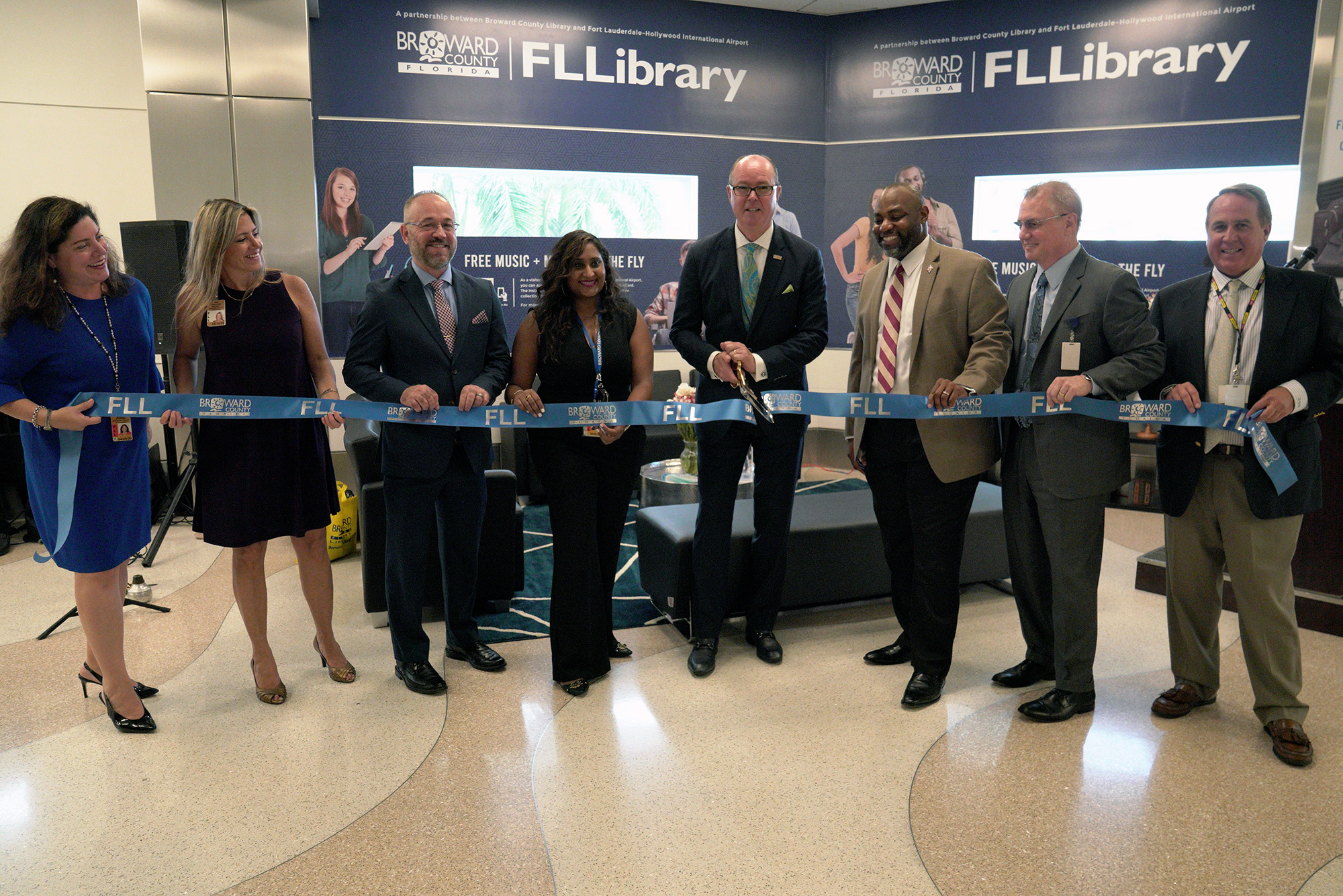 Left to right: Celina Saucedo, Aviation Asst. Director; Christina Roldan, Aviation Public Art Project Manager; Stephen Grubb, Library Public Information Officer; Ria Mohammed, Aviation Administrative Coordinator; Lamar P. Fisher, Broward County Commissioner; Kelvin Watson, Library Director; Mark Gale, Aviation Director; Greg Meyer, Aviation Public Information Officer.