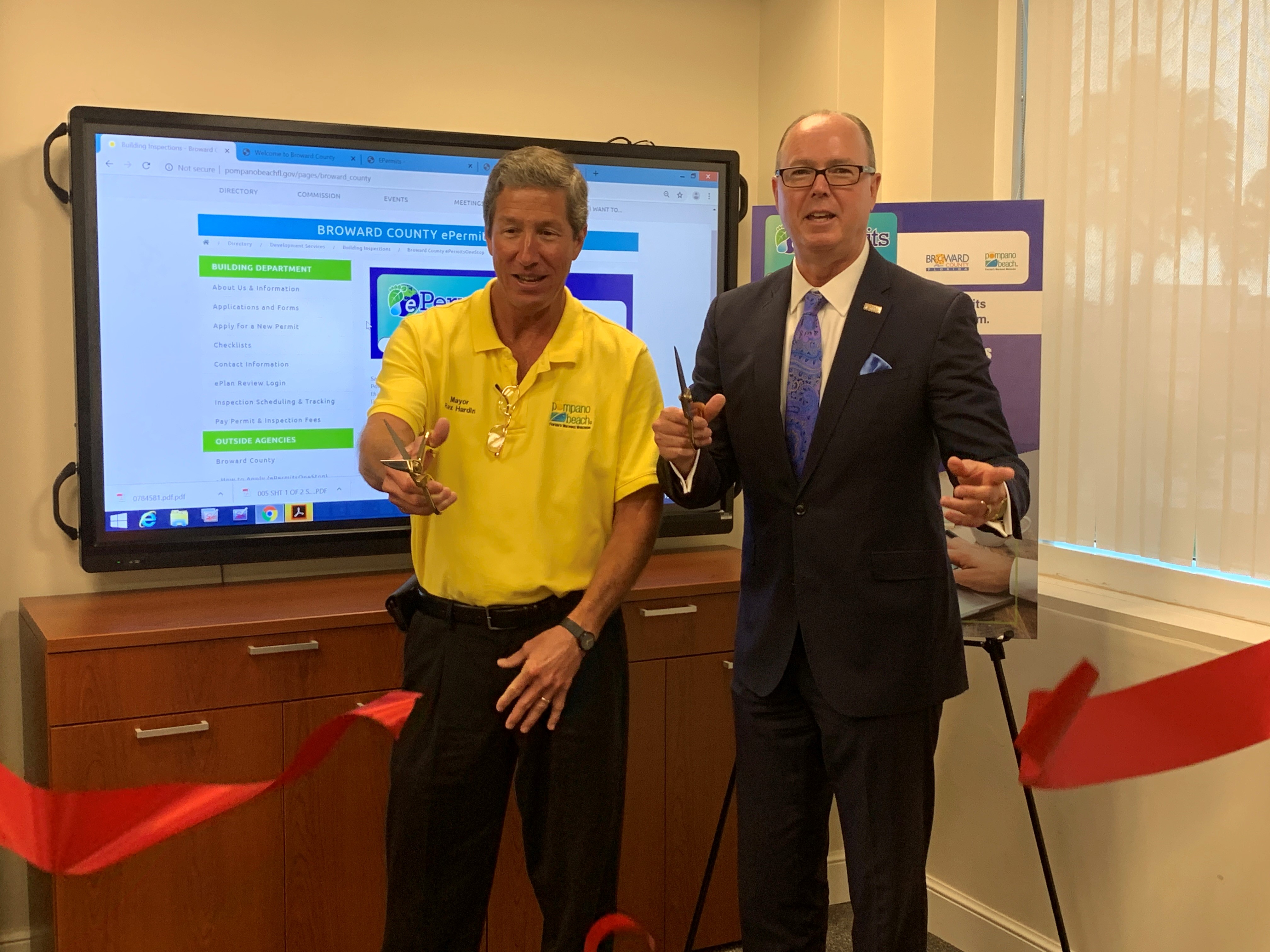 Pompano Beach Mayor Rex Hardin (left) and Broward Commissioner Lamar Fisher cut the ribbon to officially kick off the new ePermitsOneStop online permitting process now available at Pompano Beach City Hall and online. 