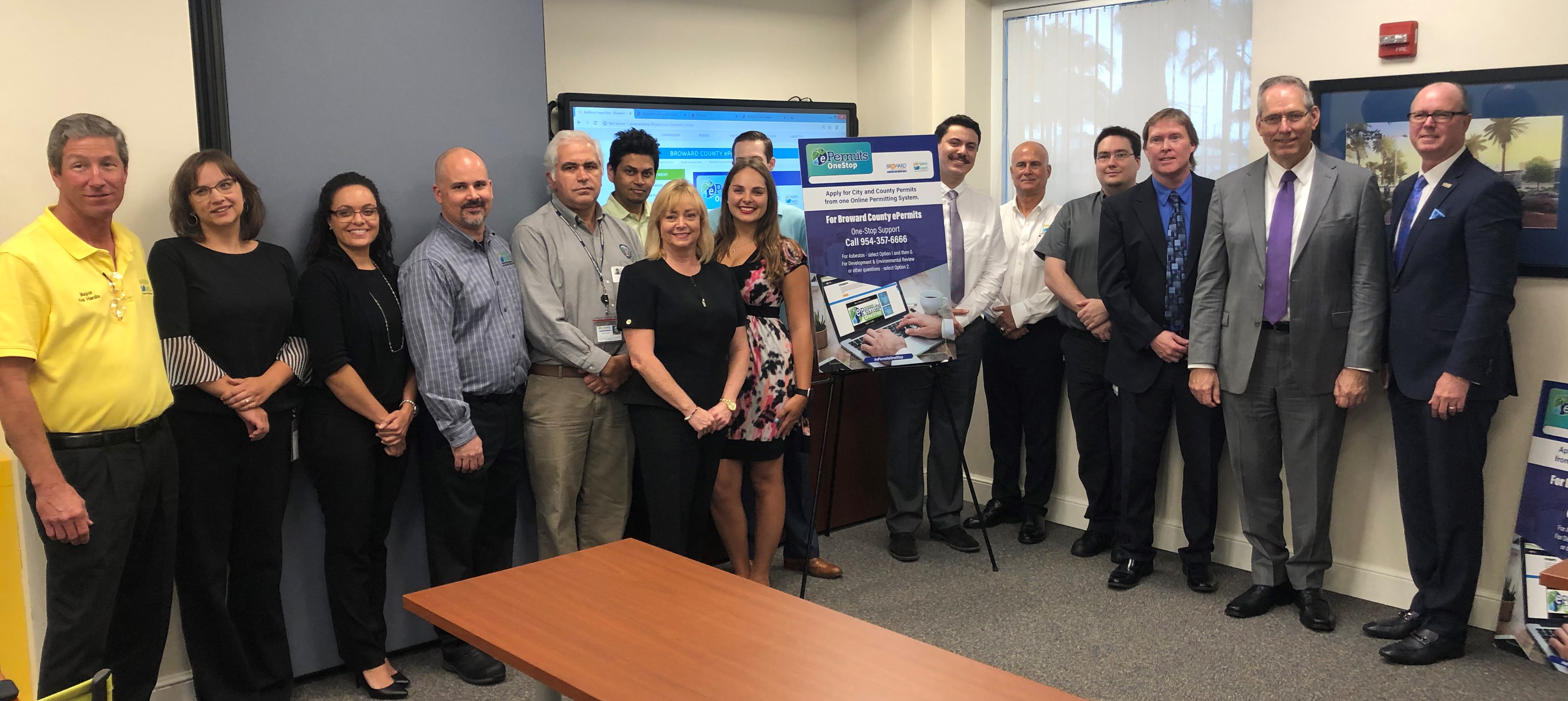 Broward Commissioner Lamar Fisher (far right of photo) and Pompano Beach City Mayor Rex Hardin join city and county employees in celebration of new ePermitsOneStop, a collaborative online service that allows customers to submit permit applications and plans online. 