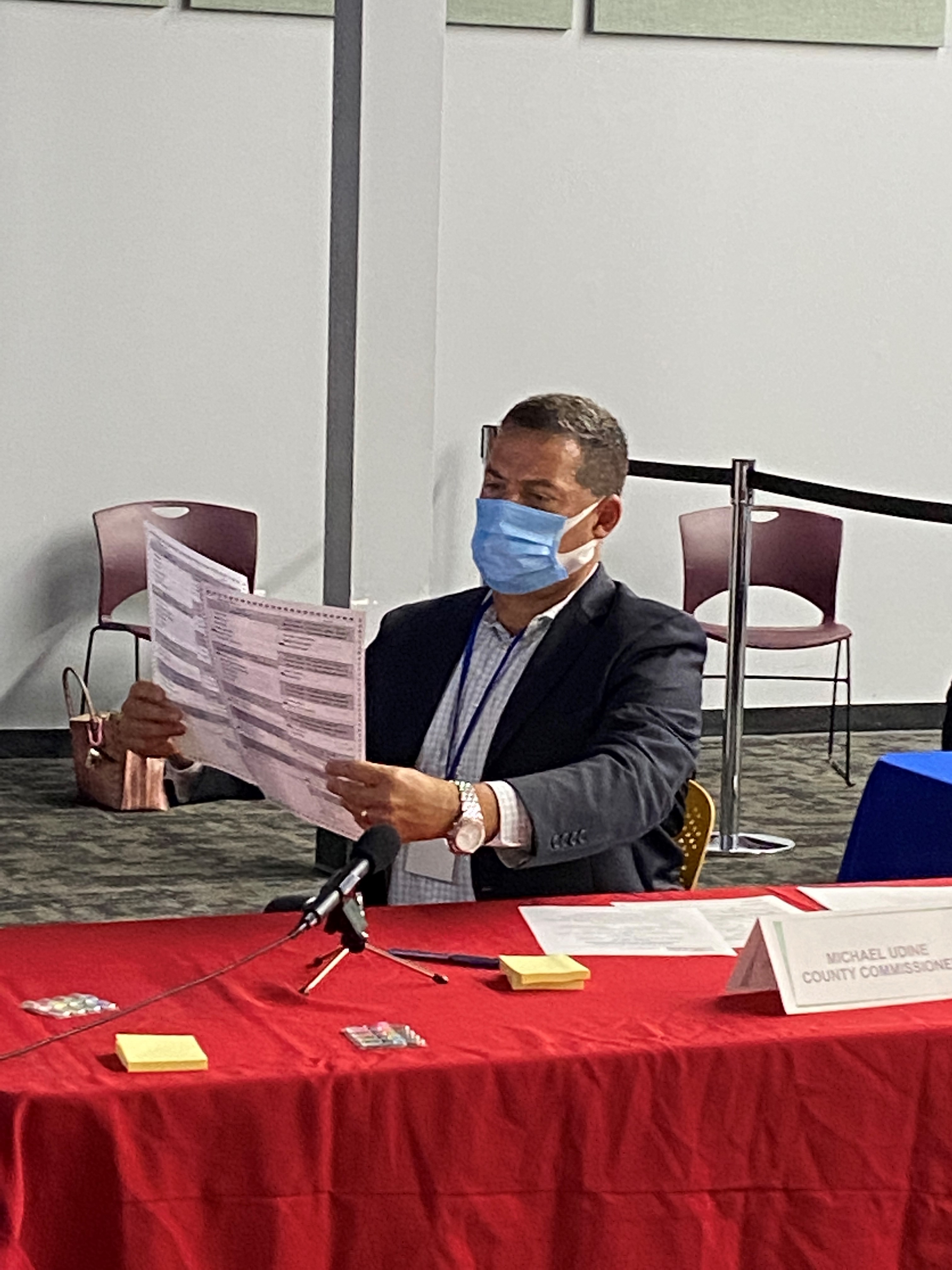 Broward Commissioner Michael Udine, Canvassing Board Member inspecting early ballots received from August primary election. 