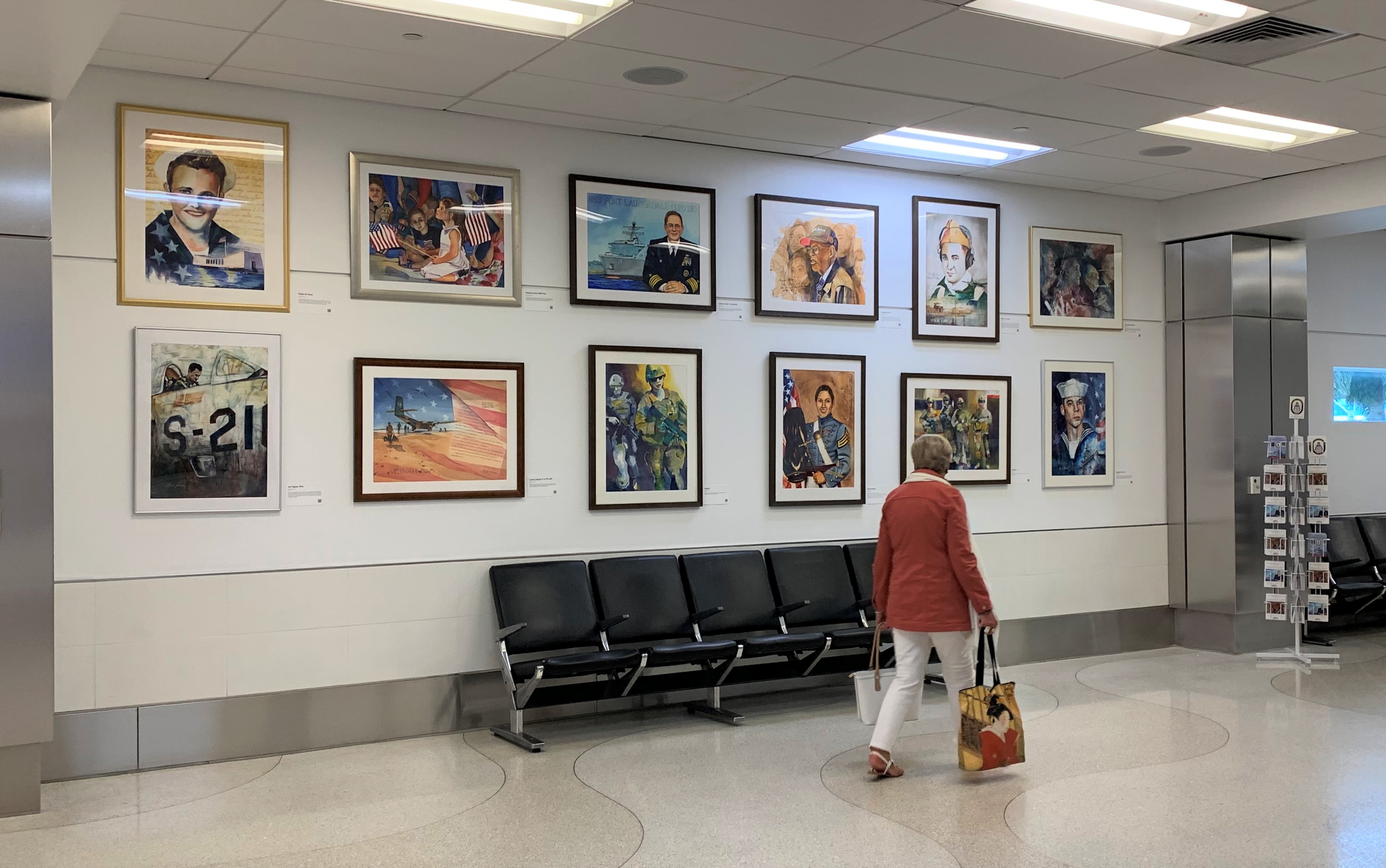 An airport guest views the new visiting military-themed art exhibit on display in July 2022 at the Fort Lauderdale-Hollywood International Airport. 